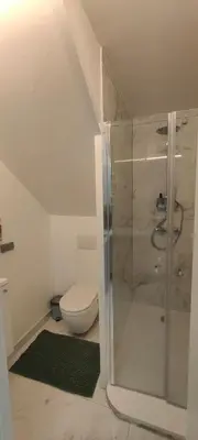 a bathroom with a toilet and a glass shower at Studio spacieux ,chaleureux et cosy in Heers