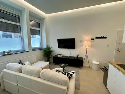 a living room with a couch and a flat screen tv at L éclipse - Luxe moderniste en plein cœur de Liège in Liège