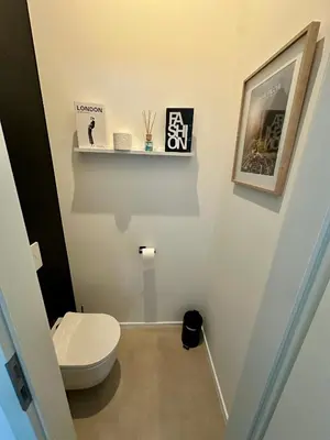 a small bathroom with a toilet and a shelf at L éclipse - Luxe moderniste en plein cœur de Liège in Liège