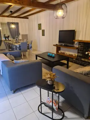 a living room with a couch and a tv at Bianca's vakantiehuis in Houthalen-Helchteren