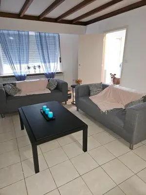 a living room with a couch and a coffee table at Bianca's vakantiehuis in Houthalen-Helchteren