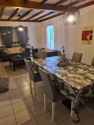 a dining room and living room with a table and chairs at Bianca's vakantiehuis in Houthalen-Helchteren