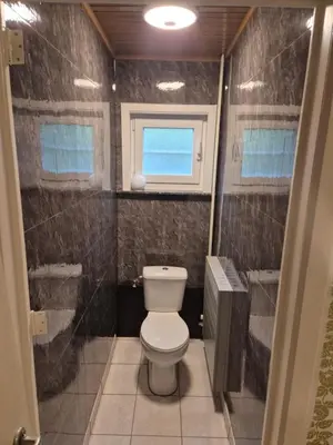a bathroom with a toilet and a window at Bianca's vakantiehuis in Houthalen-Helchteren