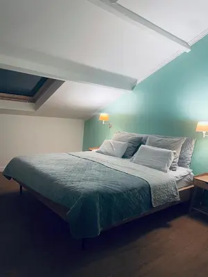 a bedroom with a large bed with a blue wall at Het Wolvennest in Maasmechelen