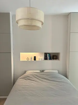 a bedroom with a bed and a light fixture at Studio Auguste in Liège