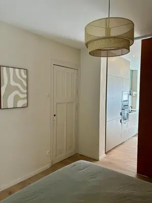 a room with a hallway with a door and a kitchen at Studio Auguste in Liège