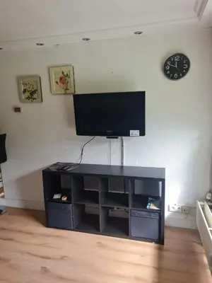 a black entertainment center with a flat screen tv on a wall at Pause Nature N in La Calamine