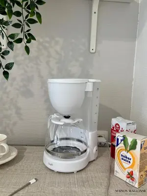 a white mixer sitting on a counter next to a box at Le studio de la Cathédrale - Hypercentre avec balcon in Liège