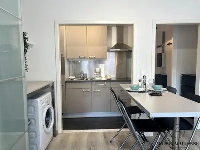 a kitchen with a table and chairs in a kitchen at Le studio de la Cathédrale - Hypercentre avec balcon in Liège