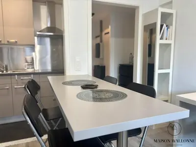 a white table with chairs in a kitchen at Le studio de la Cathédrale - Hypercentre avec balcon in Liège