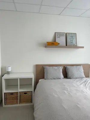 a bedroom with a bed and a shelf above it at Le Cabinet in Liège