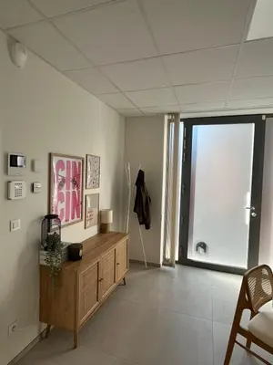 a living room with a wooden cabinet and a large window at Le Cabinet in Liège