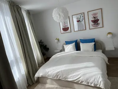 a bedroom with a large white bed with blue pillows at Appart lumineux avec terrasse au cœur de Liège in Liège