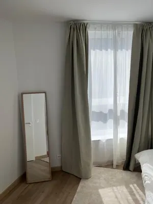 a mirror sitting next to a window with curtains at Appart lumineux avec terrasse au cœur de Liège in Liège