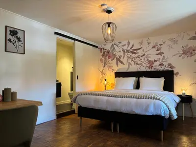 a bedroom with a bed with a flower wallpaper at Charme logies Kampernoelie in Hoeselt