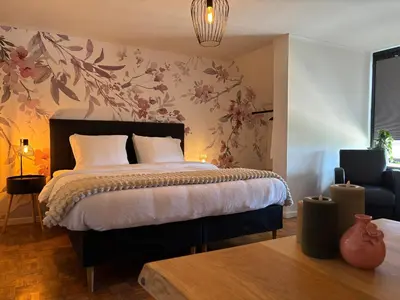 a bedroom with a bed with a floral wallpaper at Charme logies Kampernoelie in Hoeselt
