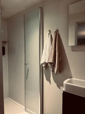 a bathroom with a shower and towels hanging on the wall at Charme logies Kampernoelie in Hoeselt
