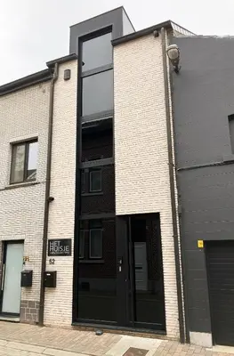 a brick building with a large glass door at Het Huisje in Tongeren