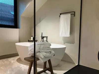 a white bathroom with a tub and a sink at Het Huisje in Tongeren