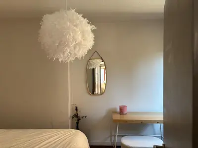 a bedroom with a bed and a mirror and a table at Le Léopold - Cocon en Hypercentre de Liège in Liège