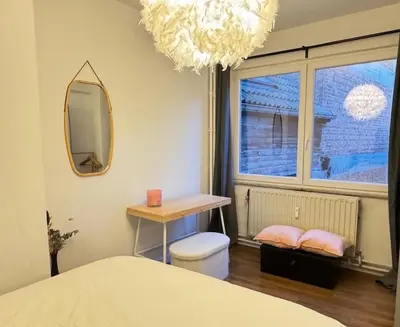 a bedroom with a bed and a table and a mirror at Le Léopold - Cocon en Hypercentre de Liège in Liège