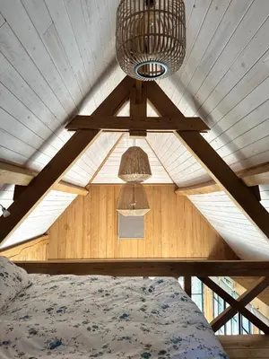 a bedroom with a ceiling with a bed and a chandelier at Green Oak House in Dilsen-Stokkem
