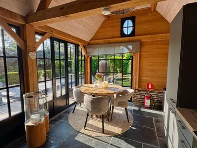 a kitchen with a wooden ceiling and a table and chairs at Green Oak House in Dilsen-Stokkem