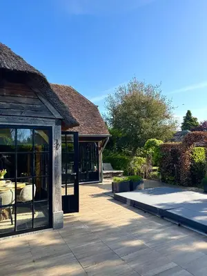 a house with a patio with glass doors at Green Oak House in Dilsen-Stokkem