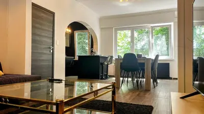 a living room with a table and a dining room at Aux Cèdres - Peaceful stay with easy parking in Liège