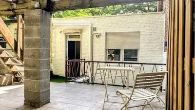 a patio with a table and chairs on a balcony at Aux Cèdres - Peaceful stay with easy parking in Liège
