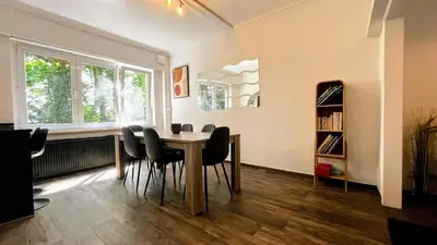 a dining room with a table and chairs at Aux Cèdres - Peaceful stay with easy parking in Liège