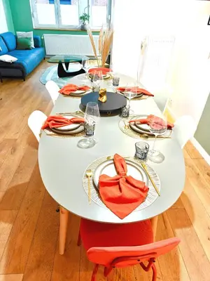 a white dining room table with red napkins on it at Maison spacieuse, sereine proche du coeur de la ville et de la gare in Liège