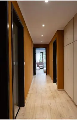 an empty hallway with wood floors in a house at Maison modernisée au caractère 70ies in Herstal