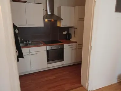 a kitchen with white cabinets and a stove top oven at Night in Liège