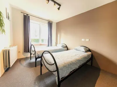 a bedroom with two beds and a window at Farmhouse with garden and wellness in Heers
