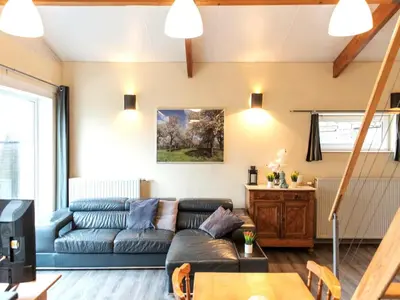 a living room with a couch and a table at Cozy duplex apartment with terrace in Heers