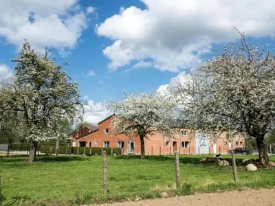 a red brick building with trees in a field at Cozy duplex apartment with terrace in Heers