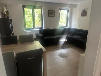 a living room with a black couch and a table at Residentie Ons Genoegen in Lommel