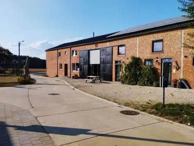 a brick building with a picnic table in front of it at Apartment with a view of alpacas in Heers