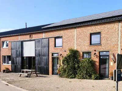 a brick building with a picnic table in front of it at Apartment with a view of alpacas in Heers