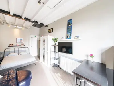 a bedroom with a bed and a desk in a room at Apartment with a view of alpacas in Heers
