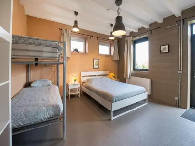 a bedroom with two bunk beds and two windows at Holiday home with garden and roofed terrace in Heers