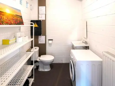 a bathroom with a toilet and a washing machine at Holiday home with garden and roofed terrace in Heers