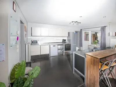 a kitchen with white cabinets and a wooden table at Single-storey holiday home in Heers in Heers