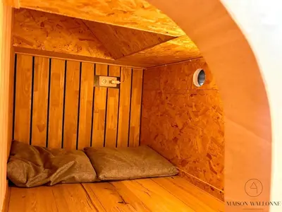 a small bed in a room with a wooden floor at La péniche de Santa Cruz - Sur la Meuse, centre ville in Liège