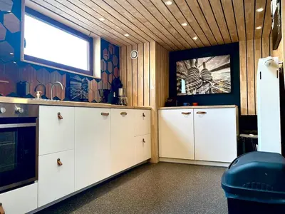 a kitchen with white cabinets and a window at La péniche de Santa Cruz - Sur la Meuse, centre ville in Liège