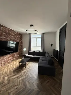 a living room with a black couch and a brick wall at Premium apartment at the gates of Liège in Liège