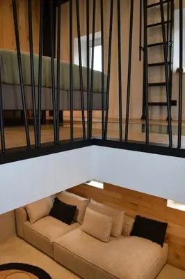 a living room with a couch and a ladder at Maison au coeur du village in Aubel