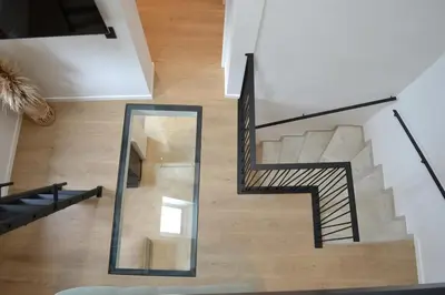 a spiral staircase in a house with a mirror at Maison au coeur du village in Aubel