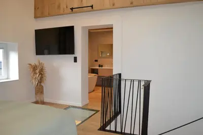 a living room with a staircase and a bathroom at Maison au coeur du village in Aubel